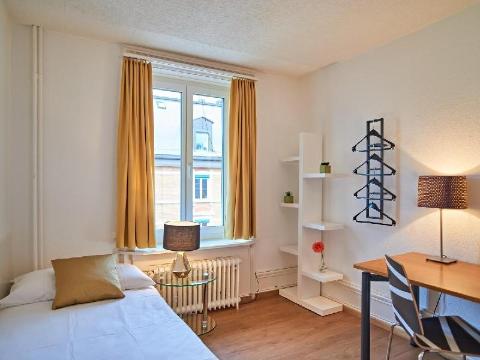 Where To Stay In Zurich, Switzerland: BEST Hotels in 2025 28 Simple bedroom with yellow curtains and study desk