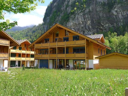 A traditional Swiss wooden house surrounded by green fields and mountains.