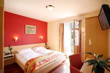 Bright hotel room with double bed and balcony