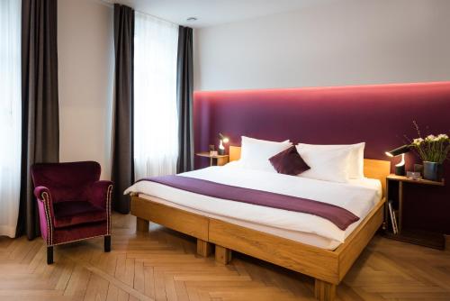 Where To Stay In Zurich, Switzerland: BEST Hotels in 2025 19 Room with purple headboard and velvet chair