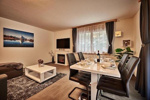 Modern dining and living area with dark leather chairs