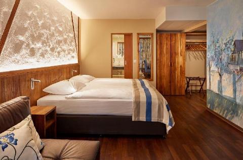 Where To Stay In Zurich, Switzerland: BEST Hotels in 2025 11 Beautiful bedroom with wood accents and painted mural wall