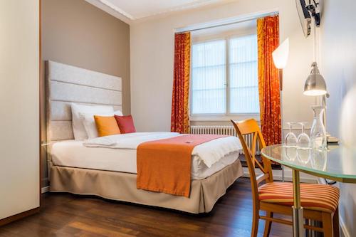 Hotel De La Paix Lucerne room and riverfront building.