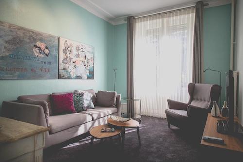 Cozy living room with mint walls and colorful artwork