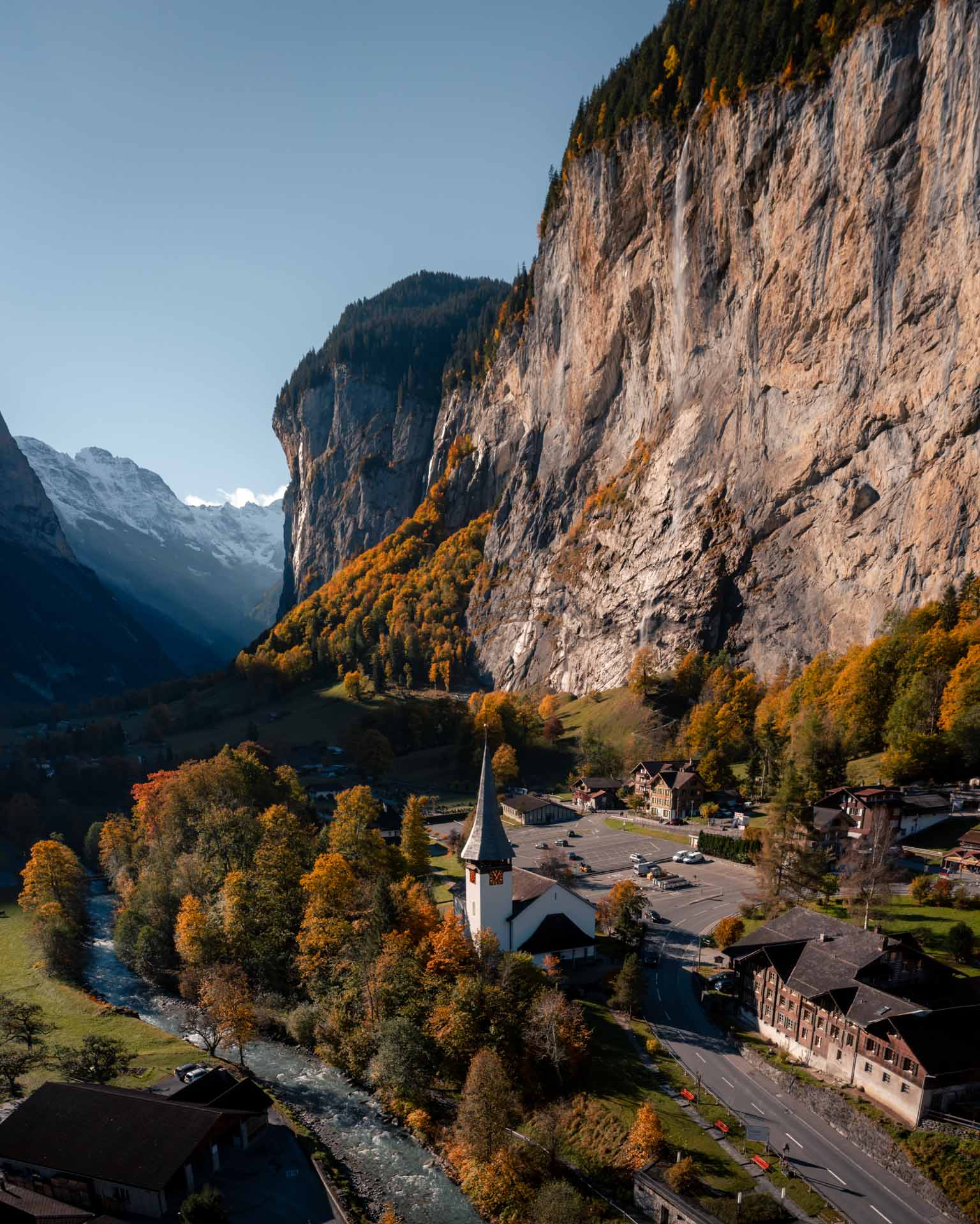 Lauterbrunnen church with cliff and autumn trees around it
