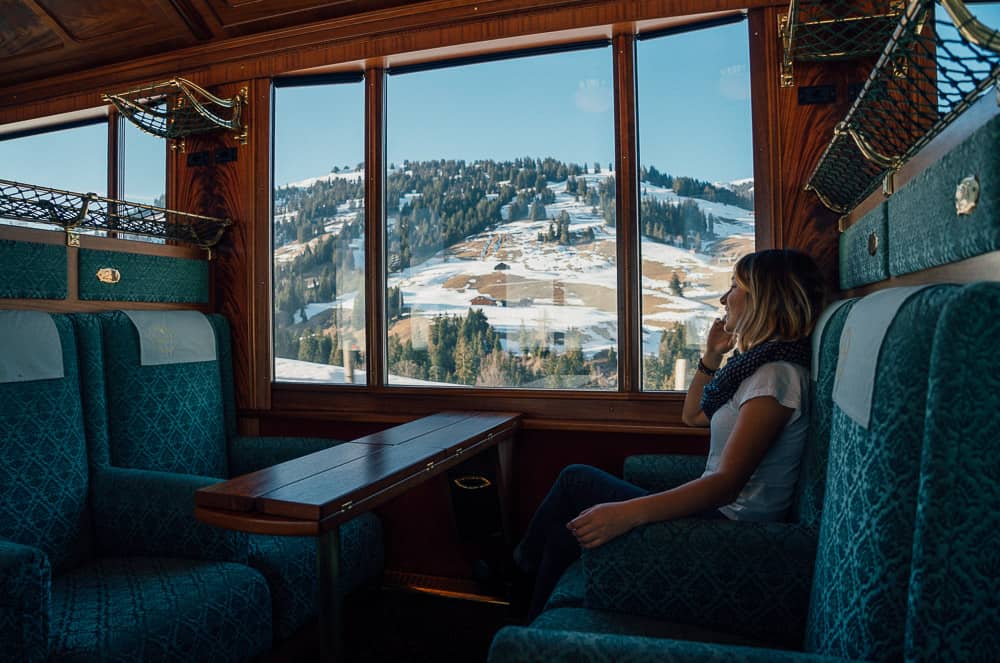 Woman on scenic Swiss train with mountain view