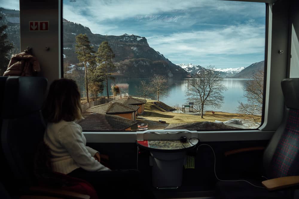 Girl on Swiss train enjoying scenic lake view