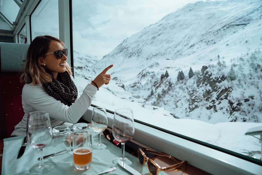 Woman pointing out the window while dining onboard the Glacier Express